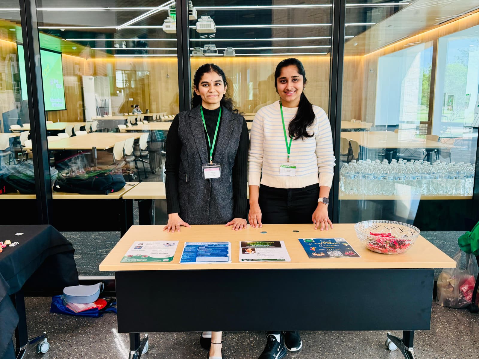 Two students standing behind a table representing the HISO student organization.
