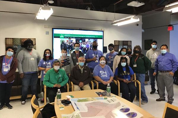 Group photo of middle school kids standing with faculty from Learning Technologies in the Agora meeting room.